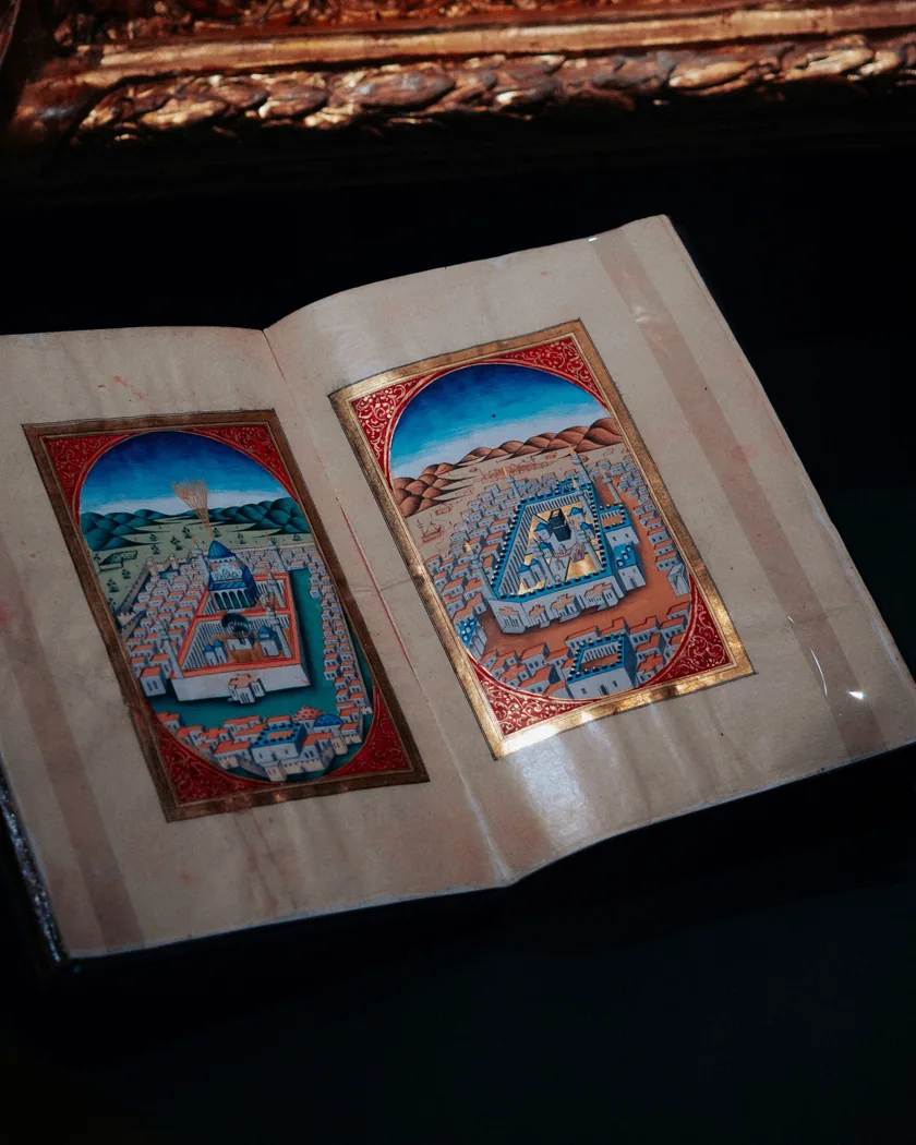 Página de manuscrito antiguo con iniciales decoradas, texto a dos columnas y pequeñas ilustraciones coloreadas